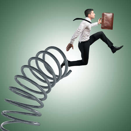 Businessman with bag jumping on a spring