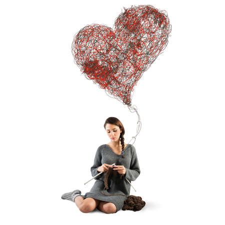Woman sews to crochet a big heartの写真素材