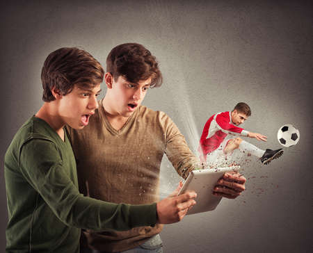 Soccer player comes out of tablet screenの写真素材