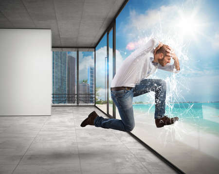 Man breaks a window of an officeの写真素材