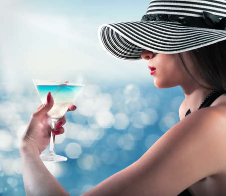 Woman looks at glass with summer landscapeの写真素材