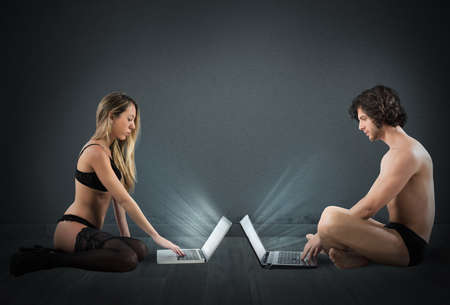 Woman and man in underwear with laptopsの写真素材