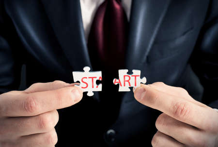 Businessman joins two pieces of the puzzleの写真素材