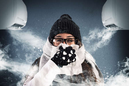 Woman with wool scarf and gloves because of air conditioning very powerful