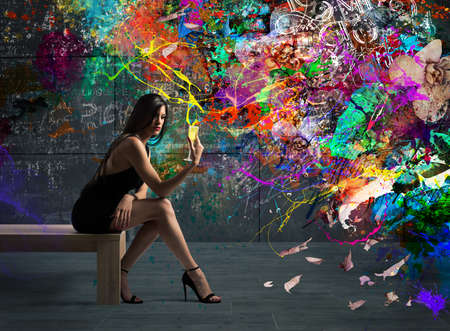 Girl with drink in hand sitting on the tableの写真素材