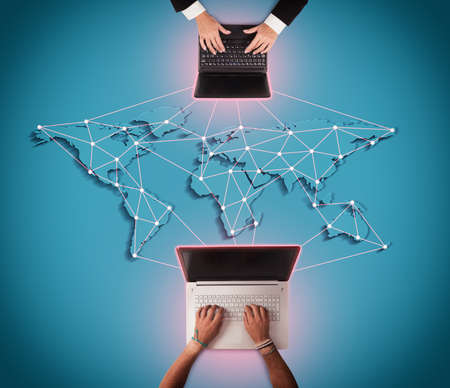 Men writes at computer with world mapの写真素材
