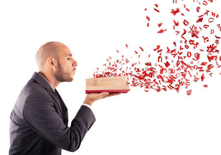 Man blows on book and fly lettersの写真素材