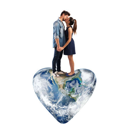 Lovely couple kissing on a heart-shaped worldの写真素材