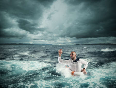 Man with lifesaver for help in a stormy seaの写真素材