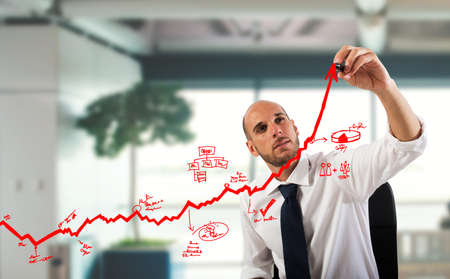 Businessman draw graphics on an arrow uphillの写真素材