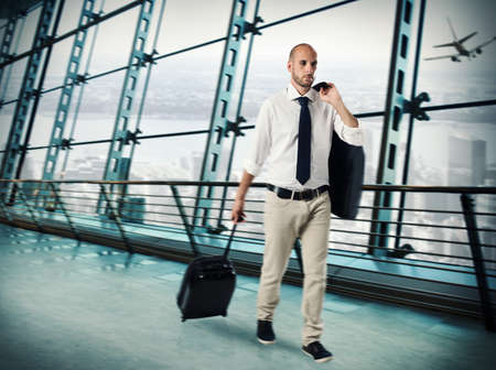 Businessman walking with trolley at the airportの写真素材
