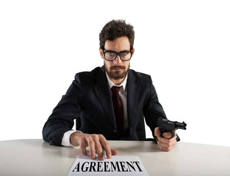 Boss forces you to sign an agreement by threatening with the gunの写真素材