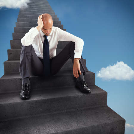 3D Rendering thoughtful businessman sitting on the steps of an infinite scaleの写真素材
