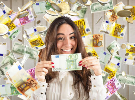 Happy businesswoman shows a 100 euro banknote with rain of money background