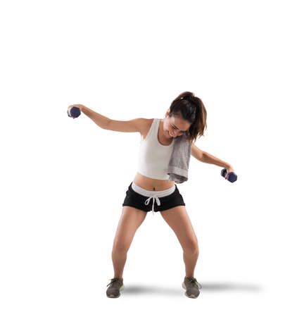 Awkward girl trying to lift weights during workoutの写真素材