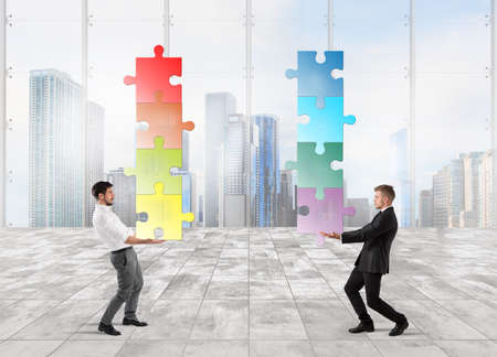 Businessmen hold a stack of puzzle fit togetherの写真素材