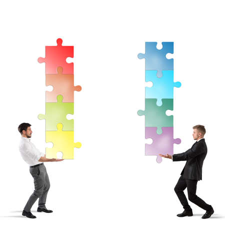 Businessmen hold a stack of puzzle fit togetherの写真素材