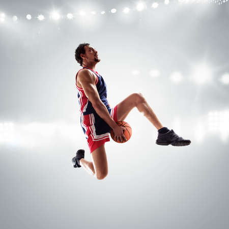 Player jumps with the ball in the stadium full of spectatorsの写真素材