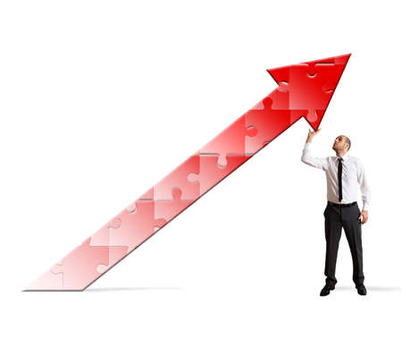 Businessman holding a puzzle with arrow pointing upの写真素材