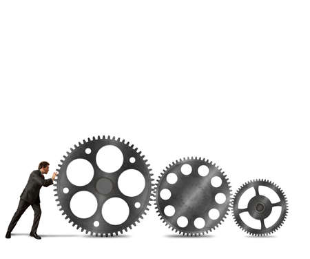 Businessman pushes a system mechanism of gearsの写真素材