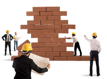 Team of architects working and analyzing on a bricks construction projectの写真素材