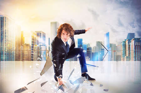 Business man punch with power and determination in the floor of roofの写真素材