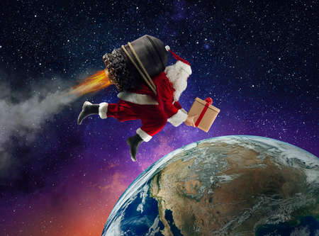 Santa Claus with gift box flies with a missile in a spaceの写真素材