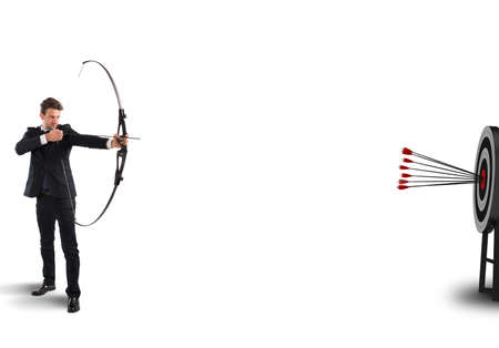Businessman with bow and arrows hits targetの写真素材
