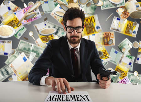 Boss forces you to sign an agreement by threatening with the gunの写真素材