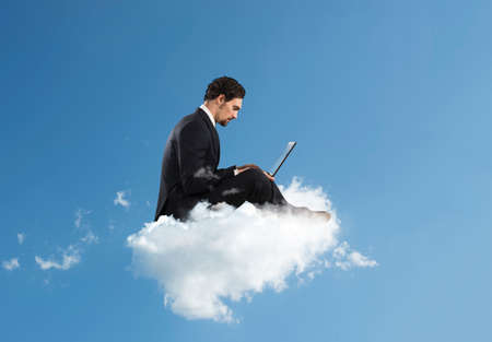Businessman with laptop on a cloud in the sky. Internet and social network concept