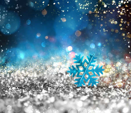 Background of Xmas decoration with sparkly silver crystal with shiny blue snowflakeの写真素材