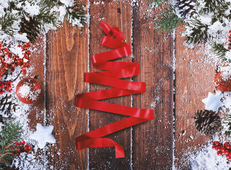 Christmas grunge decoration with xmas tree of ribbon snow pine cones and hawthorn berries on wooden background
