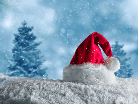 Red velvet Christmas hat of Santa Claus on the snowの写真素材
