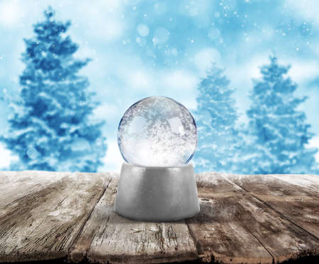 Xmas snowball on wooden planks on background with snowy landscapeの写真素材