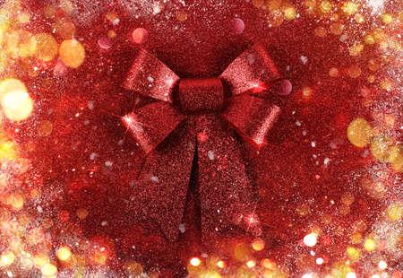 Glittering red ribbon with bow for xmas on sparkly backgroundの写真素材