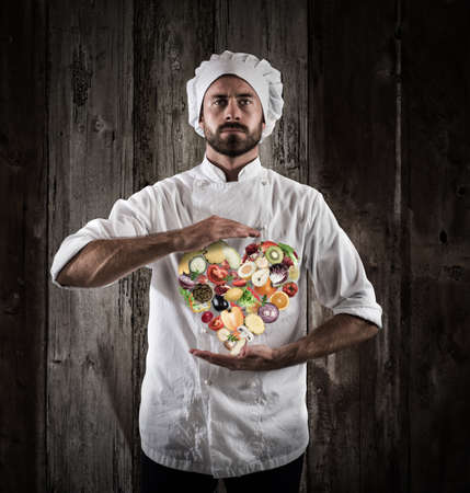 Chef specialized in vegetarian with fresh vegetables. Healthy food for wellness conceptの写真素材