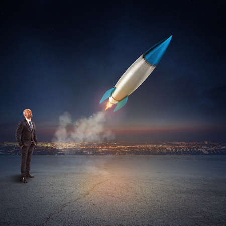Businessman looks start a missile. Concept of company startup and new business. 3D Rendering.の写真素材