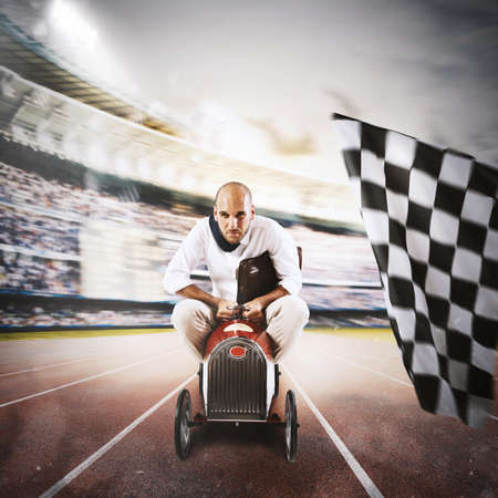 Successful businessman in a small car on the finishing lineの写真素材