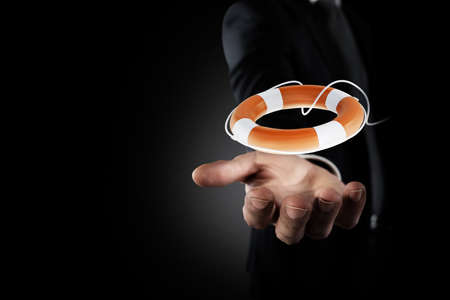 Businessman that hold a lifebelt. Concept of insurance and help in your businessの写真素材