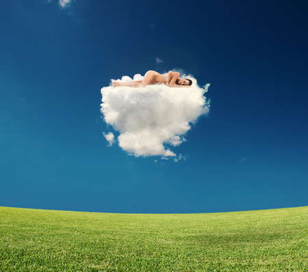 Young woman sleeps on a cloudの写真素材