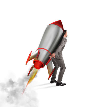 Determination and power businessman that holds a rocket isolated on white backgroundの写真素材