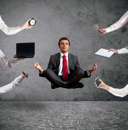 Relaxed businessman that does yoga during the workの写真素材