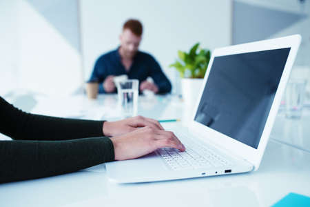 Girl works on a laptop in office. Concept of internet sharing and interconnection