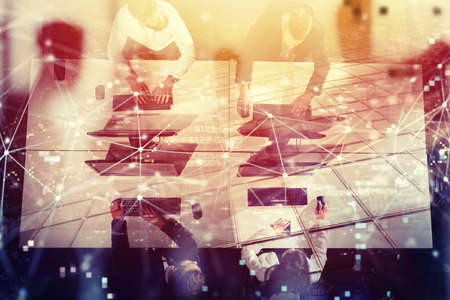 Businessperson in office work together with network effect. concept of partnership and teamwork. double exposureの写真素材