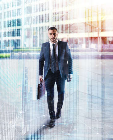 Determinated businessman walking in the city. double exposureの写真素材