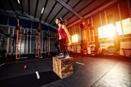 Athletic girl does box jump exercises at the gymの写真素材