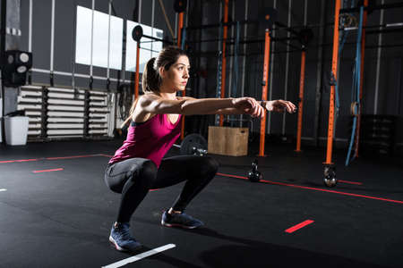 Athletic girl does squat exercises at the gymの写真素材