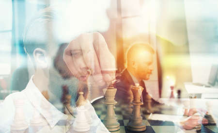 Business tactic with chess game and businessmen that work together in office. Concept of teamwork, partnership and strategy. double exposureの写真素材