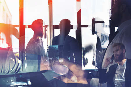 Businessmen that work together in office. Concept of teamwork and partnership. double exposureの写真素材