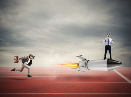 Winner businessman over a fast rocket. Concept of business competitionの写真素材
